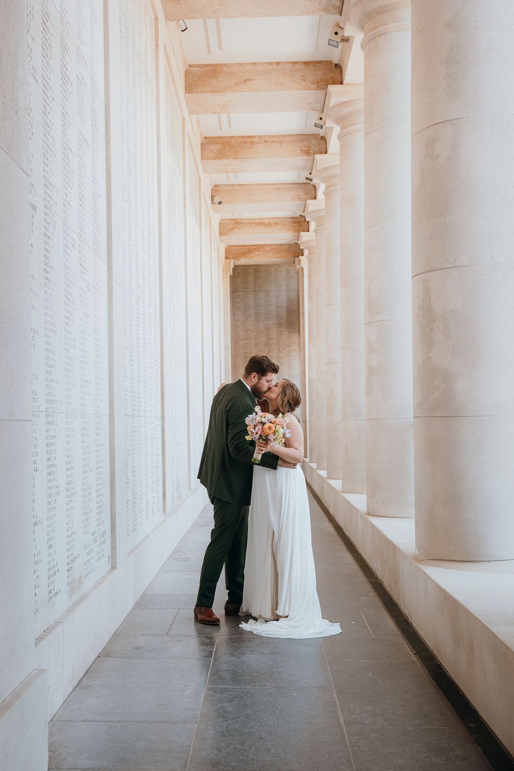 White columned hallway with minimalist architecture creating a dramatic wedding portrait setting.