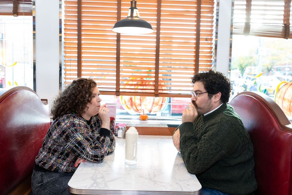 Engaged Couple sips milkshake at Bel-Aire Diner in Astoria, Queens.