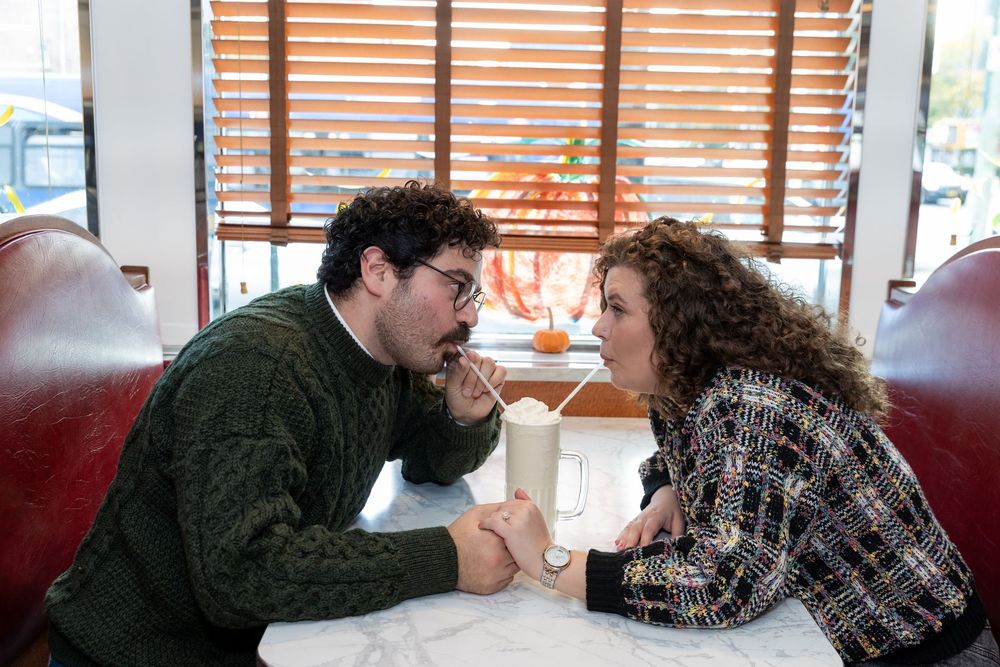 Engaged Couple sips milkshake while holding hands at Bel-Aire Diner in Astoria, Queens.
