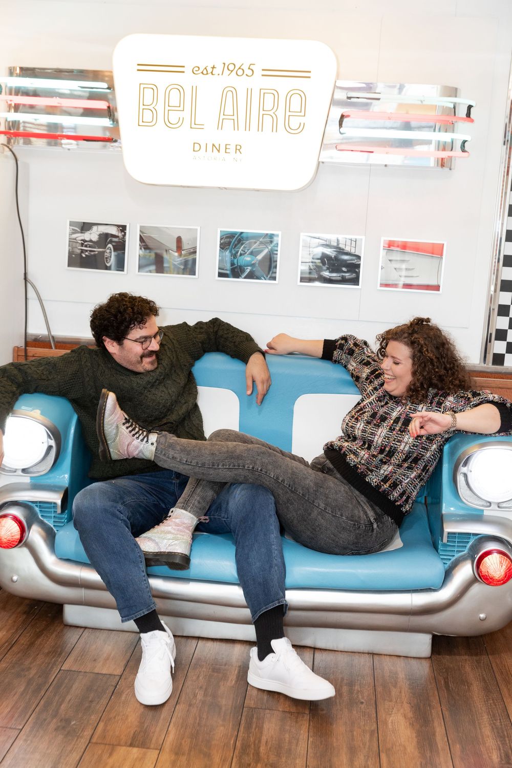 Engaged Couple plays during photo session at Bel-Aire Diner in Astoria, Queens.