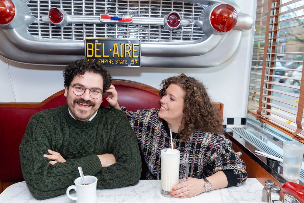Engaged Couple sips coffee during photo session at Bel-Aire Diner in Astoria, Queens.