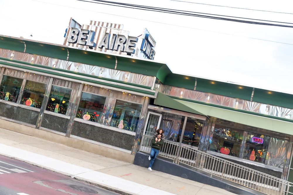 Engaged Couple poses for photos outside Bel-Aire Diner in Astoria, Queens.