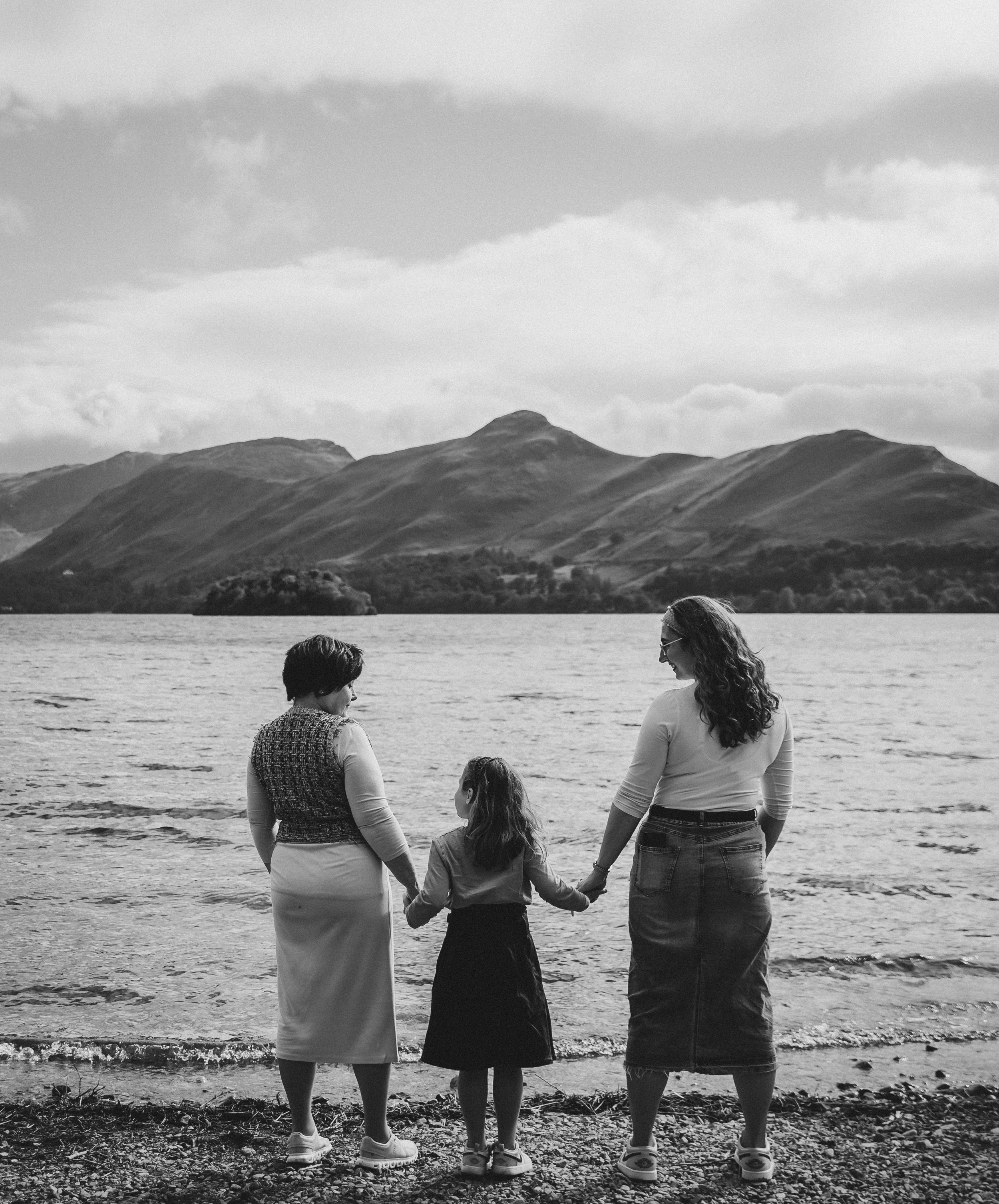 Mother and daughters looking at the lake scenic family photography, lakeside photoshoot