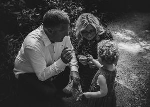 Black and white candid of family huddled together moody family photography storytelling image.