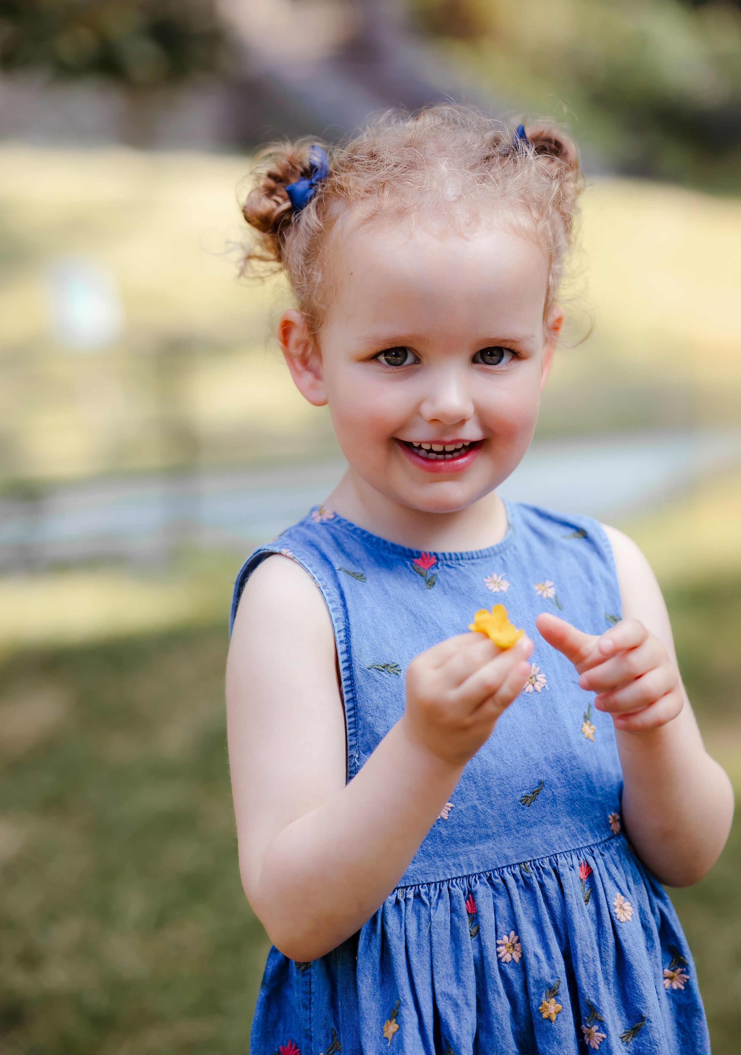 Child smiling and holding flowers Cheerful child portrait garden family photoshoot