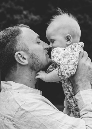 Father kissing baby black and white emotional family portrait timeless photography.