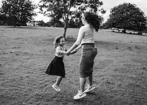 mother dancing with daughter in a field black and white candid family moment artistic photos