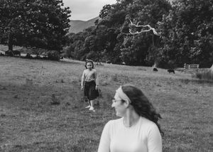 Mother walking in a meadow with children Documentary family photography outdoor exploration