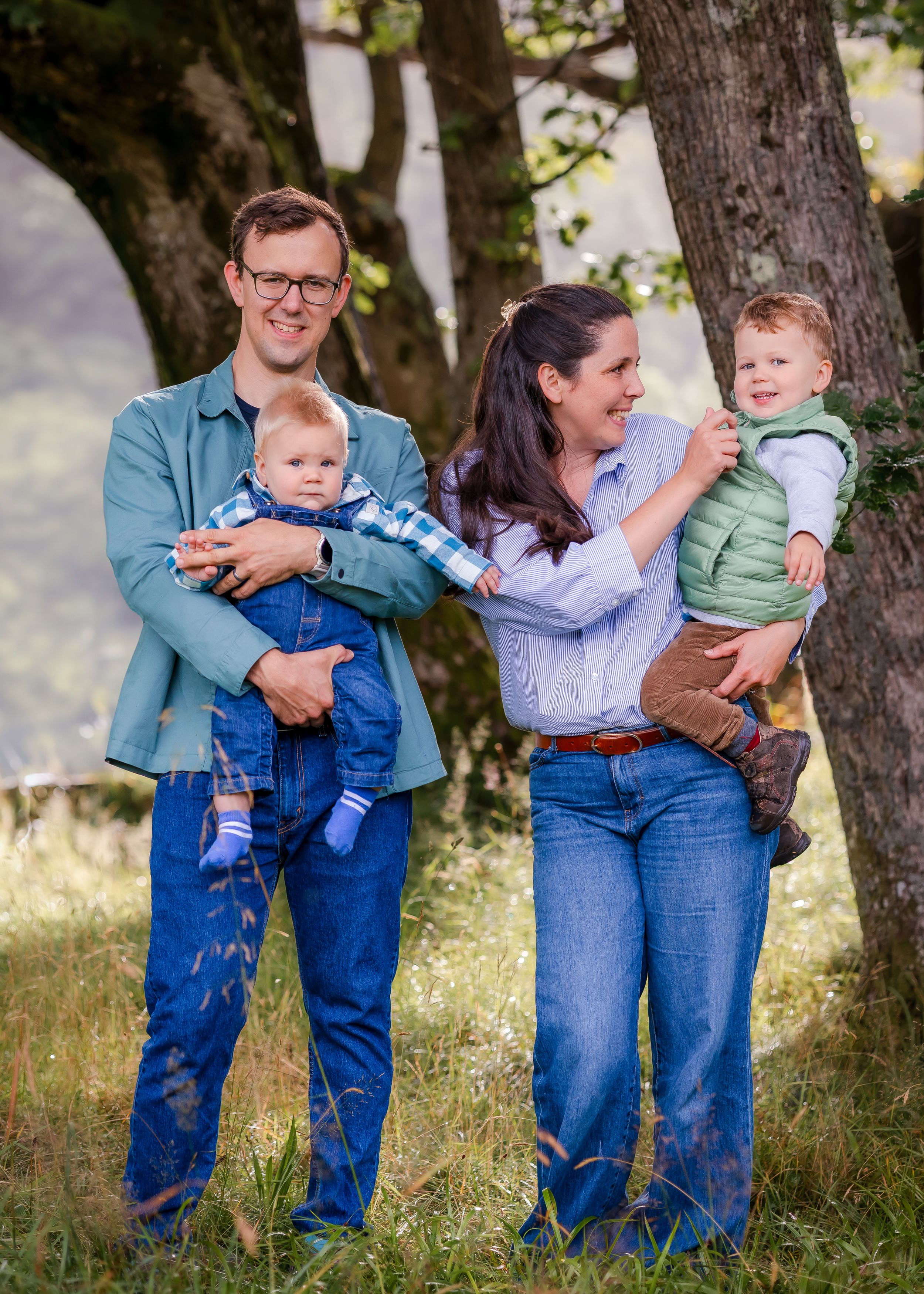 Parents with two young children under a tree Family portrait session near you.