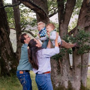 parents lifting child up into the air joyful family photoshoot, nature family photography