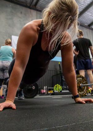 Sequence of pushup positions on black gym flooring during workout.