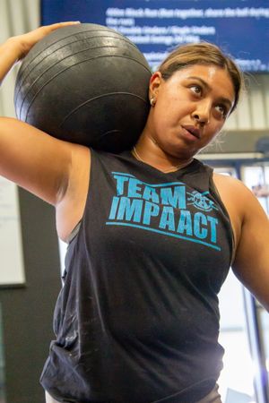Person wearing black Impact team tank top during workout session.