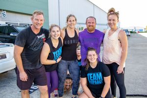 Group of fitness enthusiasts posing together after an outdoor workout session.