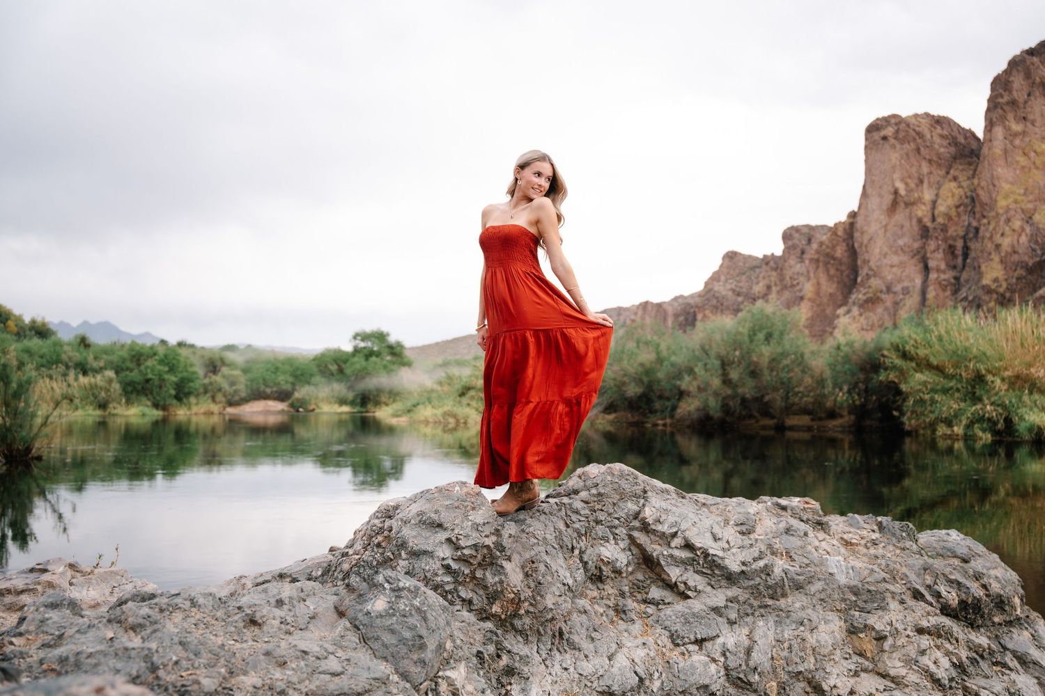 Des Moines senior portrait photographer capturing joyful young woman in flowing red dress at golden hour Iowa landscape