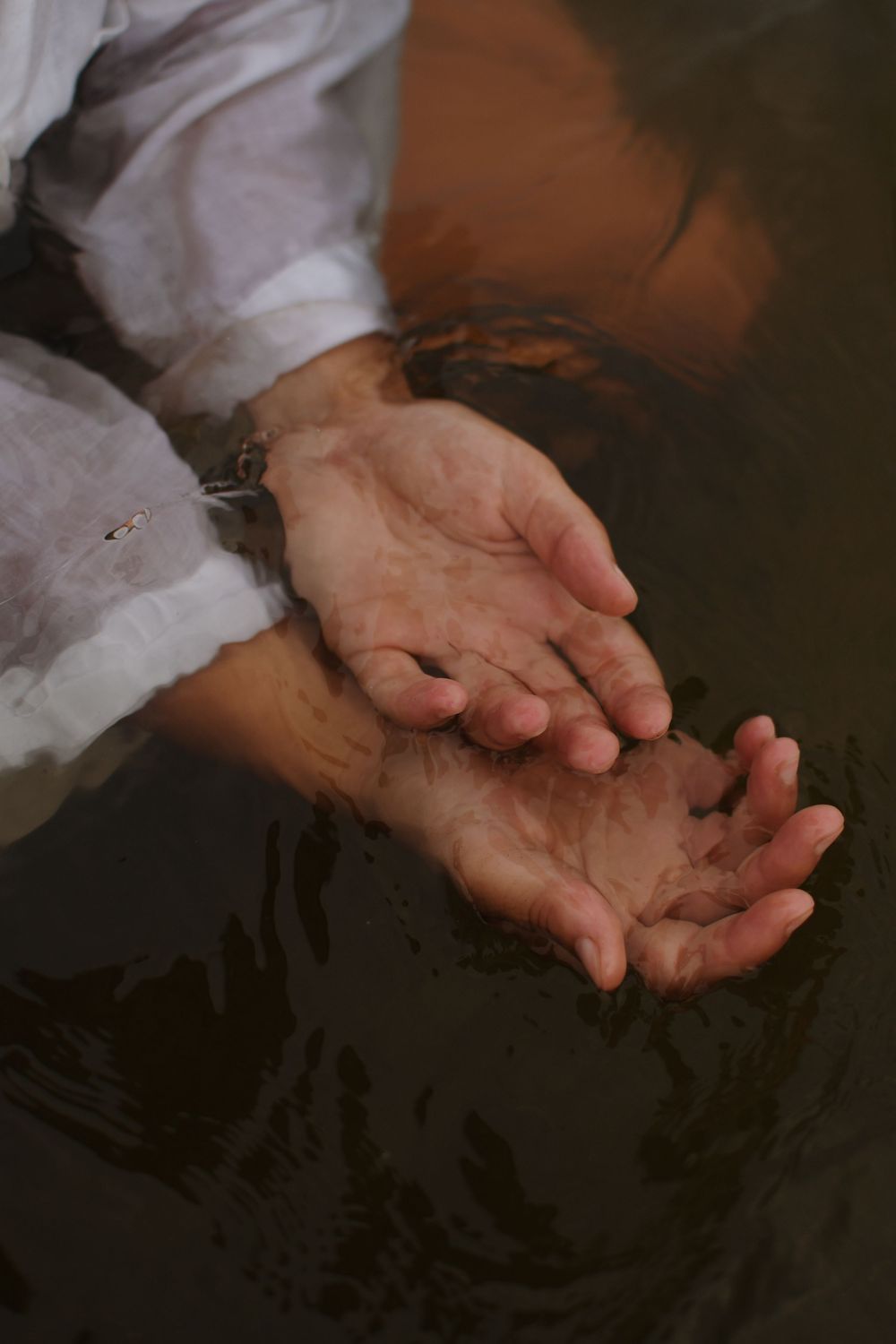 Hands cupped together in a series of photos showing different angles against a dark background.