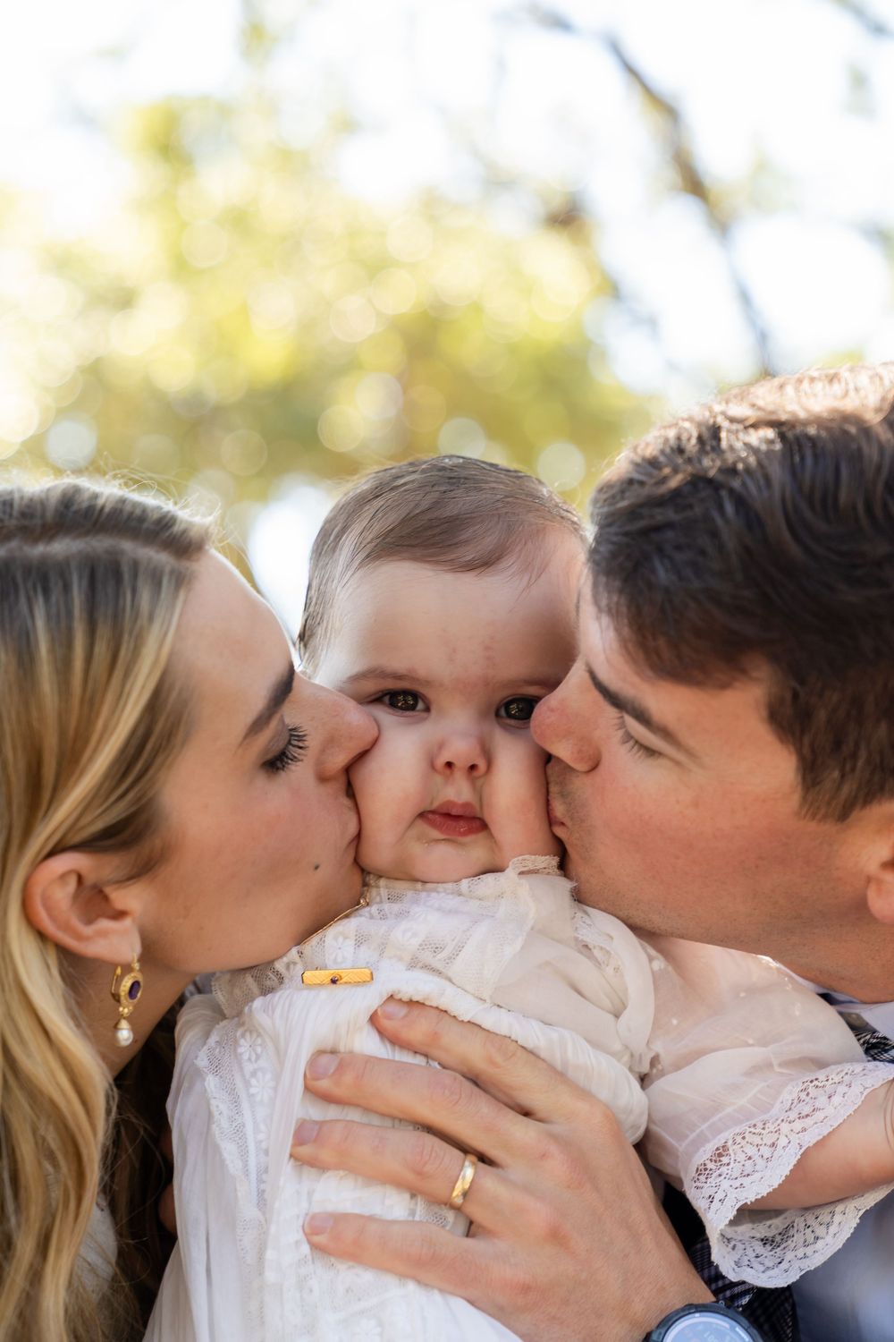 A sweet family moment captured in a series of photos showing parents kissing their baby's cheeks.