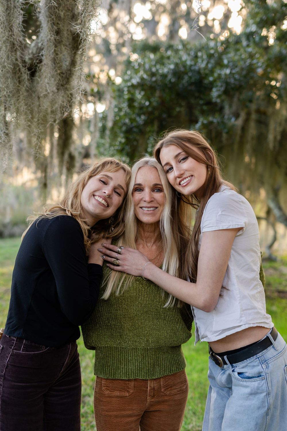 A series of four candid outdoor photos showing three people embracing and laughing together in a natural setting.
