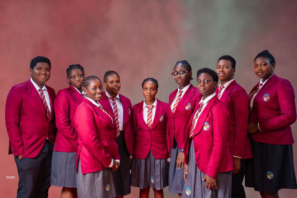 Students in bright red school uniforms posed together for group photo.