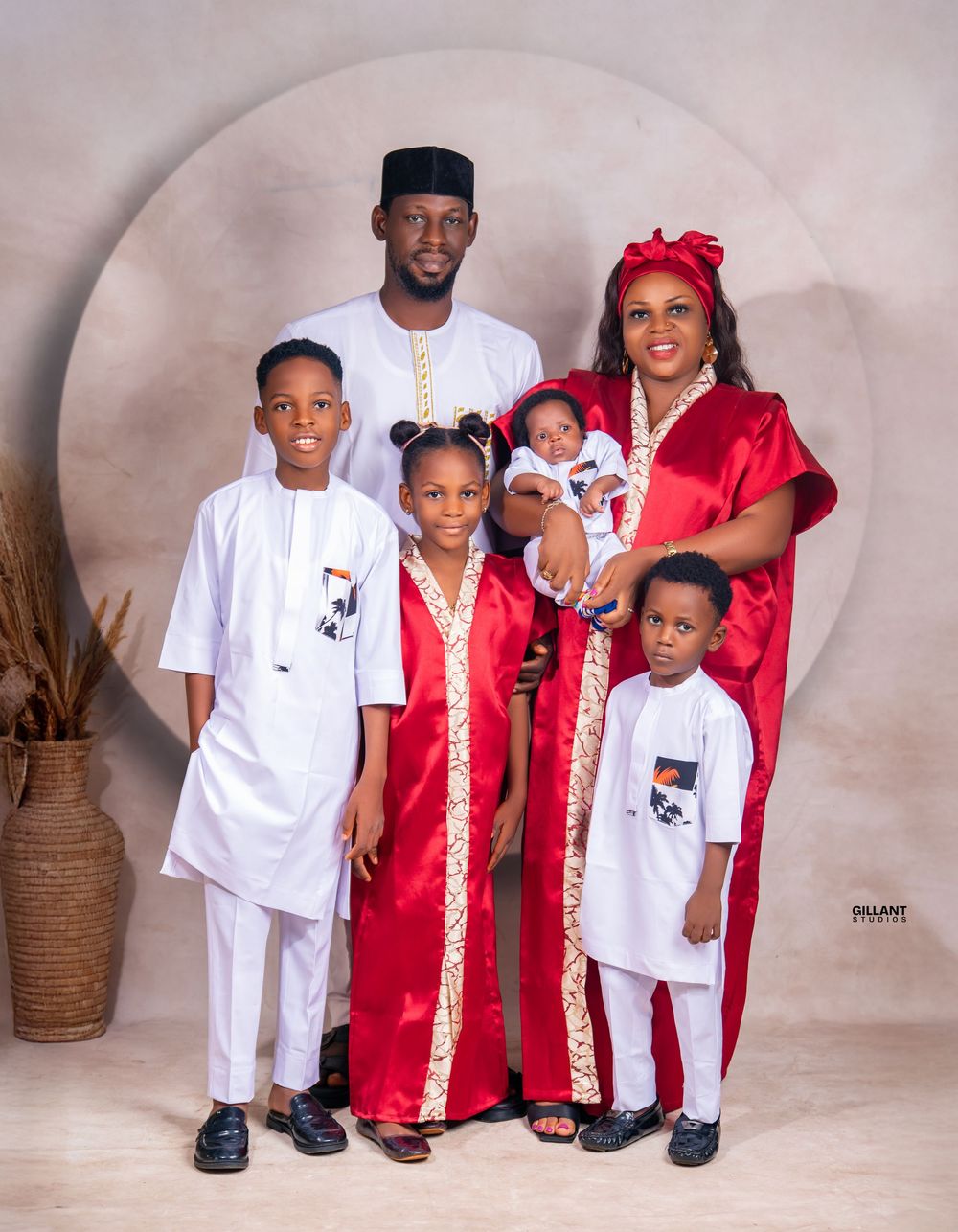 Traditional family portrait with coordinated white and red cultural attire.