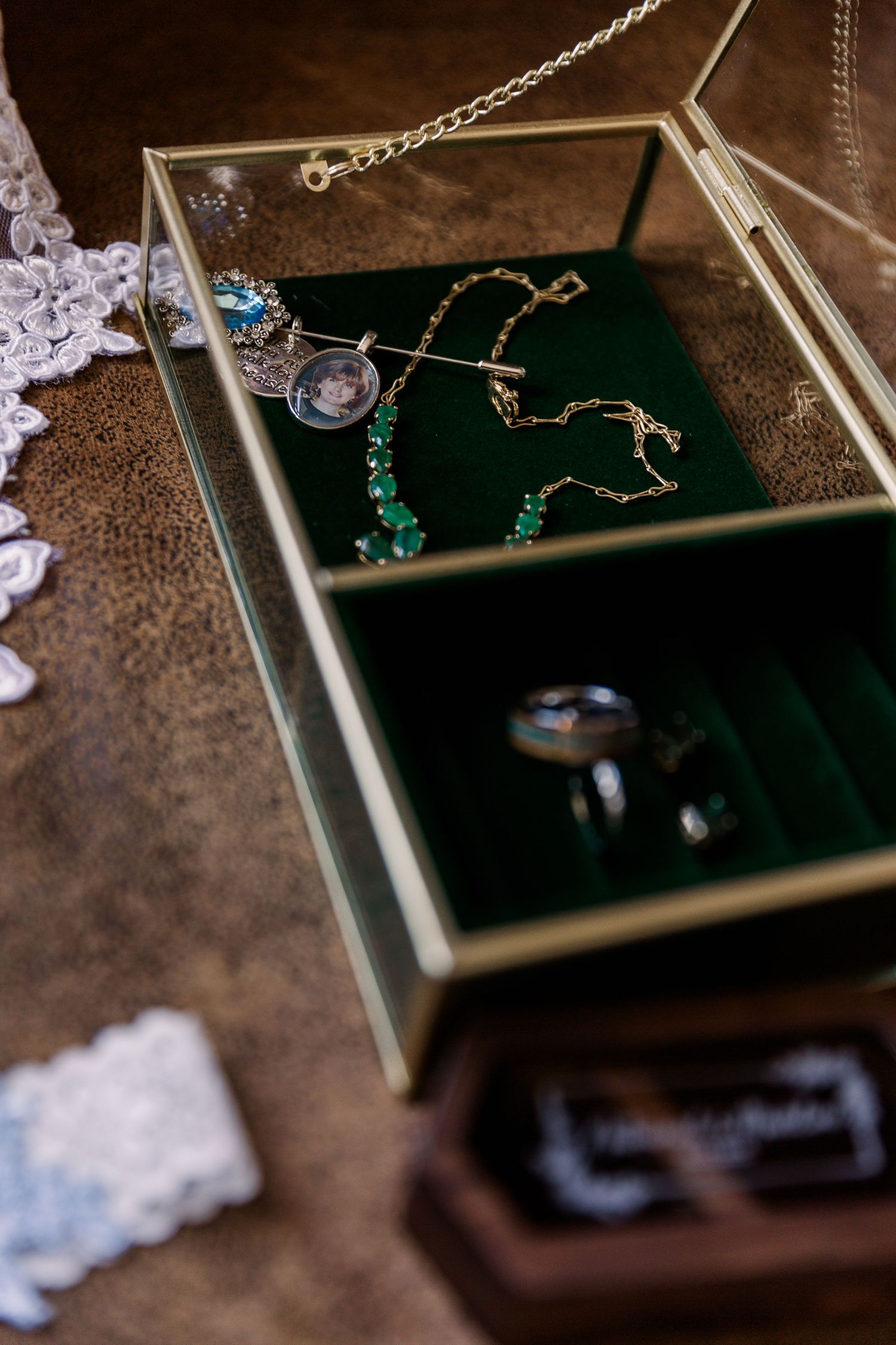 Wedding jewelry and accessories displayed on a dark velvet tray with delicate lace details.
