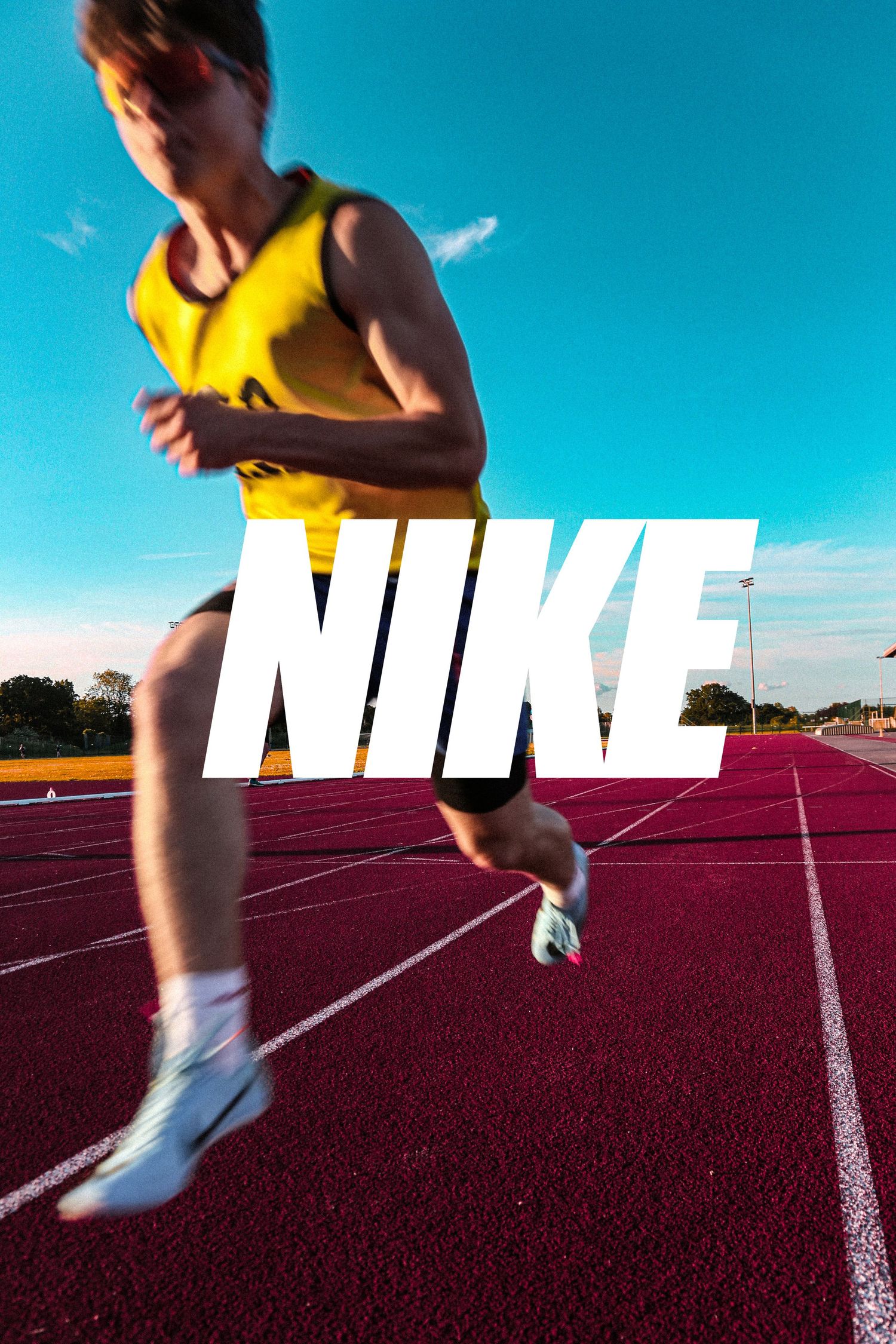 Dynamic running shot with Nike logo overlay on red track against blue sky.