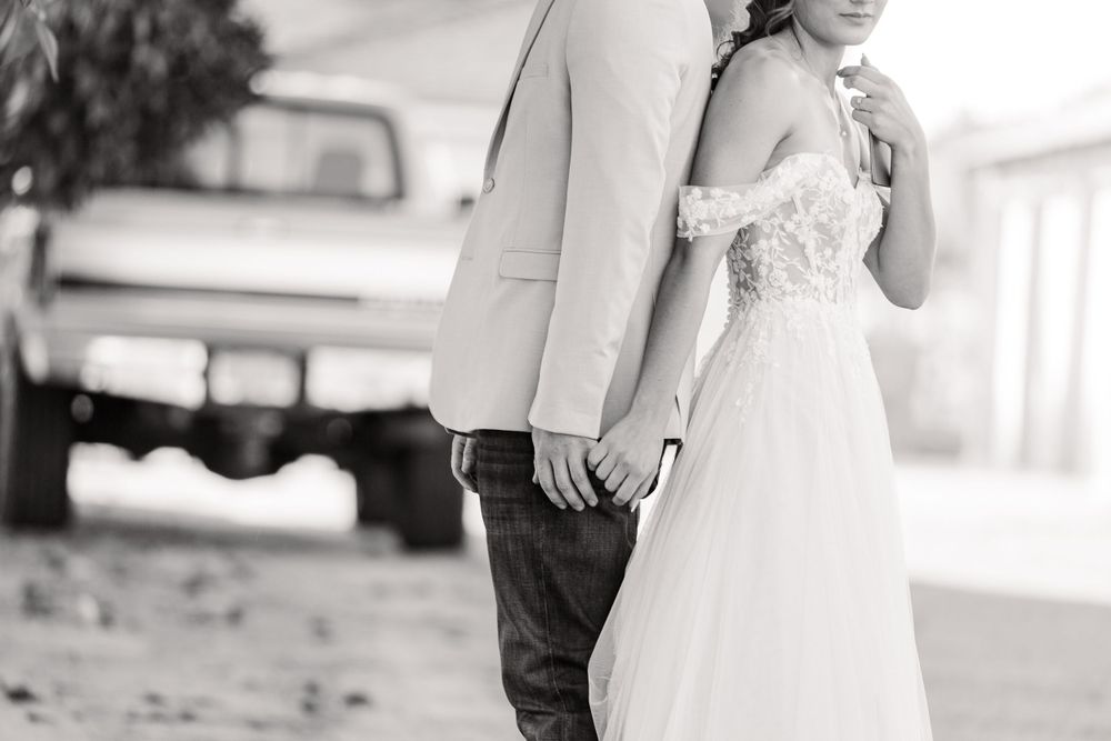 Black and white wedding photo showing a romantic moment between a couple.