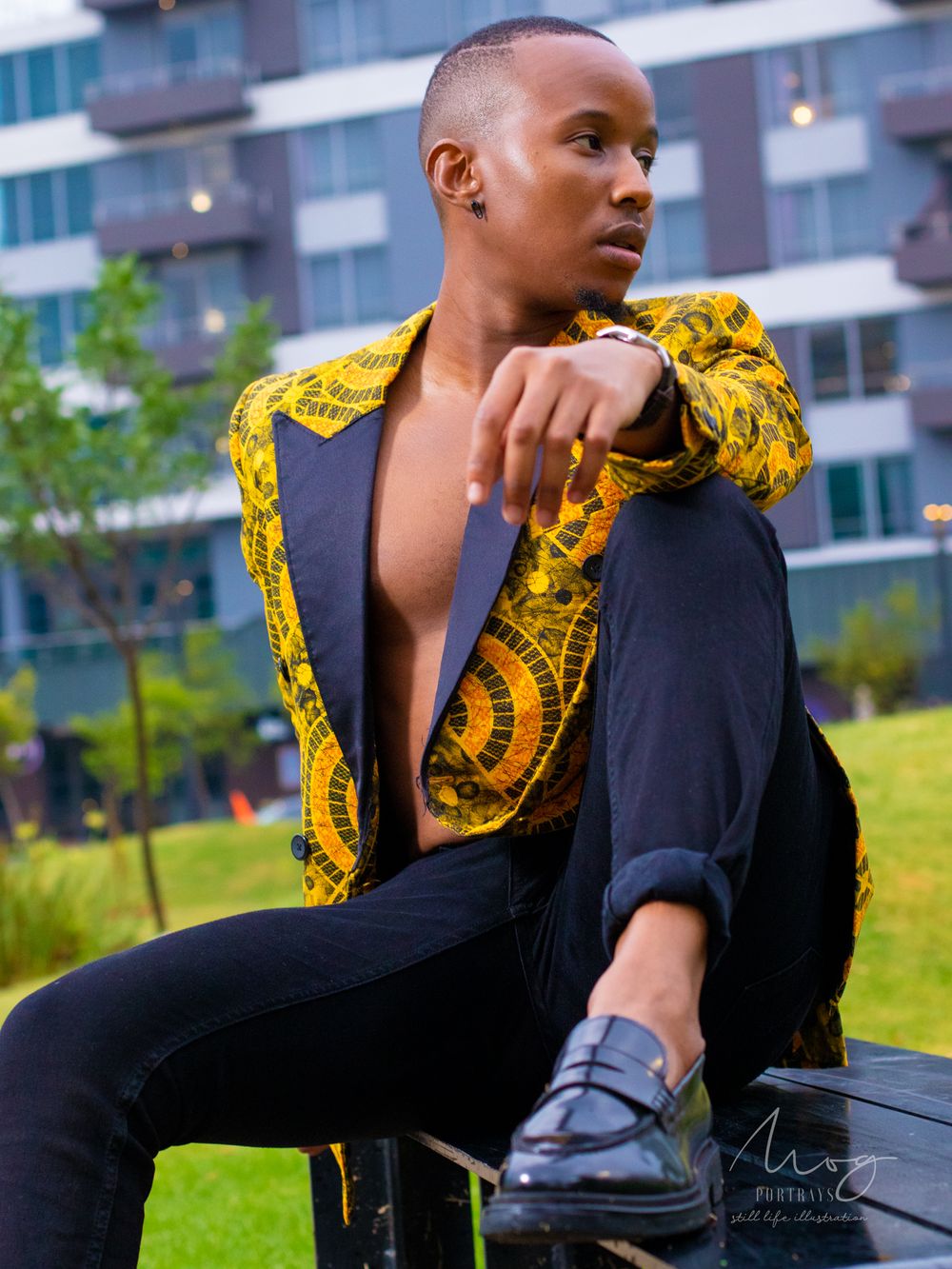 Street style photo showcasing black and yellow patterned jacket against urban backdrop.