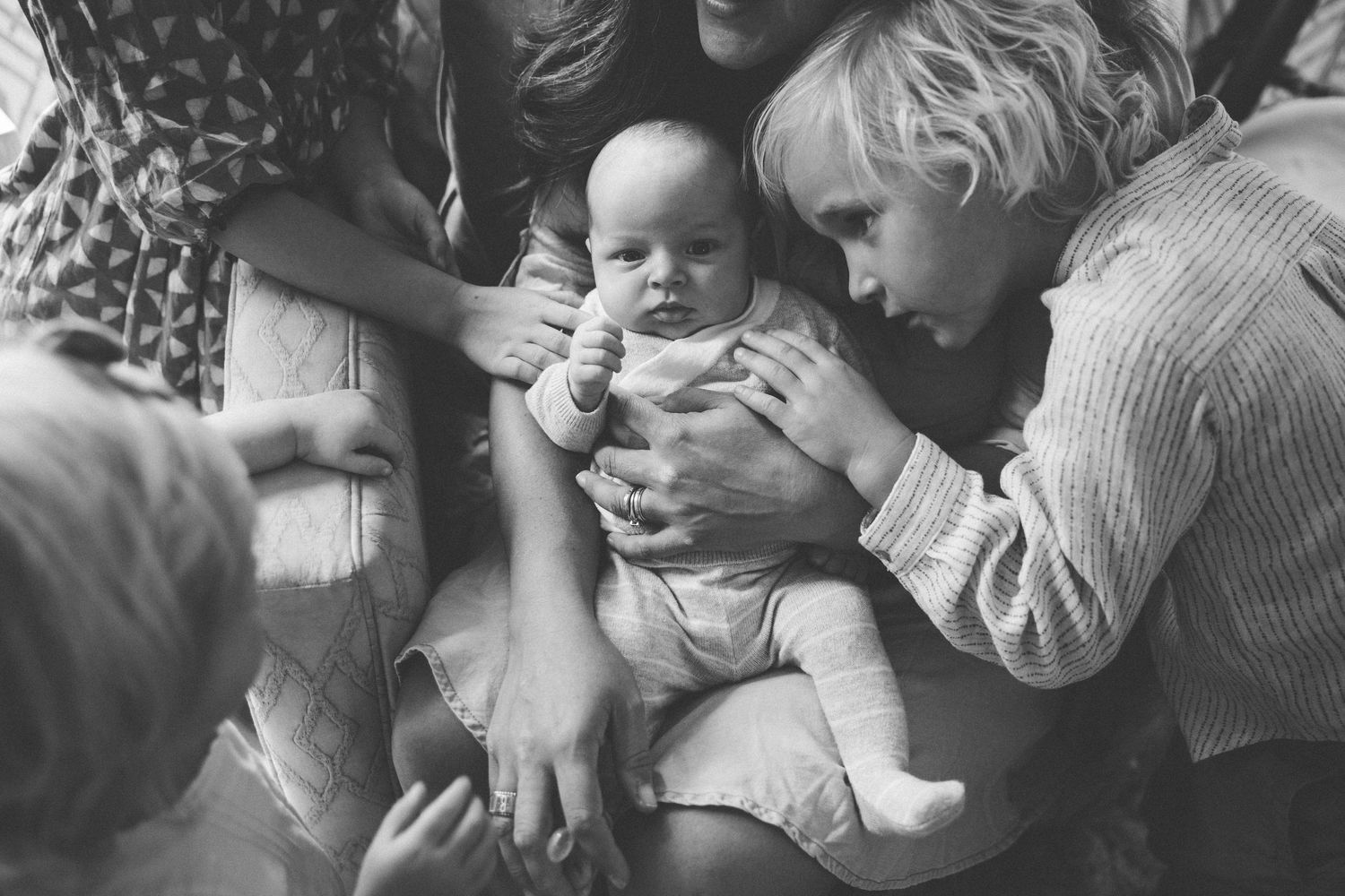 Black and white newborn lifestyle moments between brothers captured in natural light.