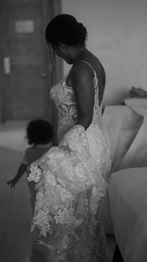 A beautiful lace wedding dress being worn in a black and white portrait photograph.
