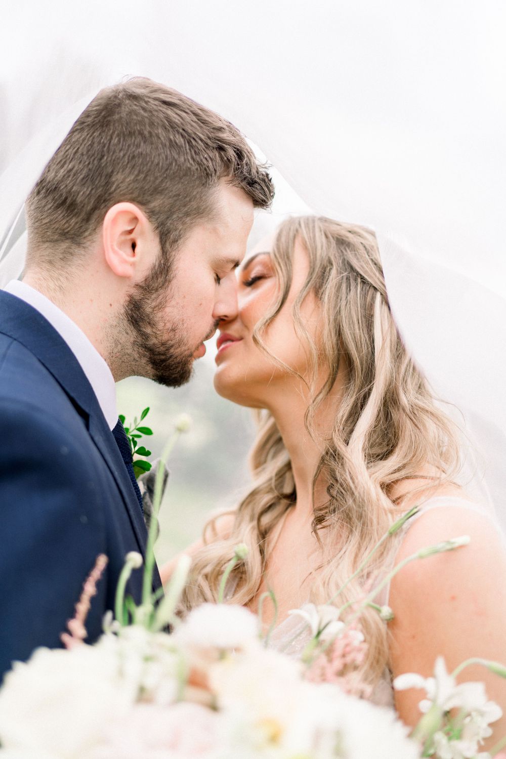 fine art image bride and groom going in for a kiss under veil at Swancar Farm and Country House