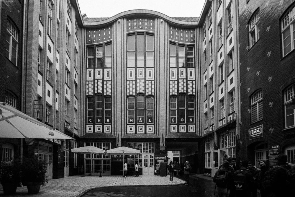 Art deco style building entrance with tall windows and geometric patterns in black and white.