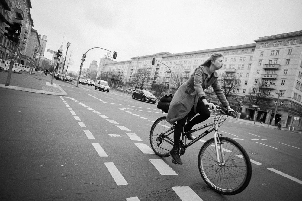 A cyclist performs a trick on a BMX bike in an urban street setting.