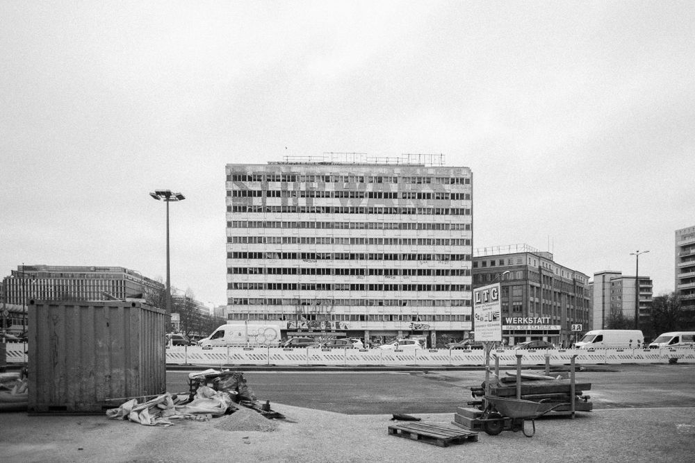 A Soviet-era apartment block stands against an overcast sky in an urban setting.