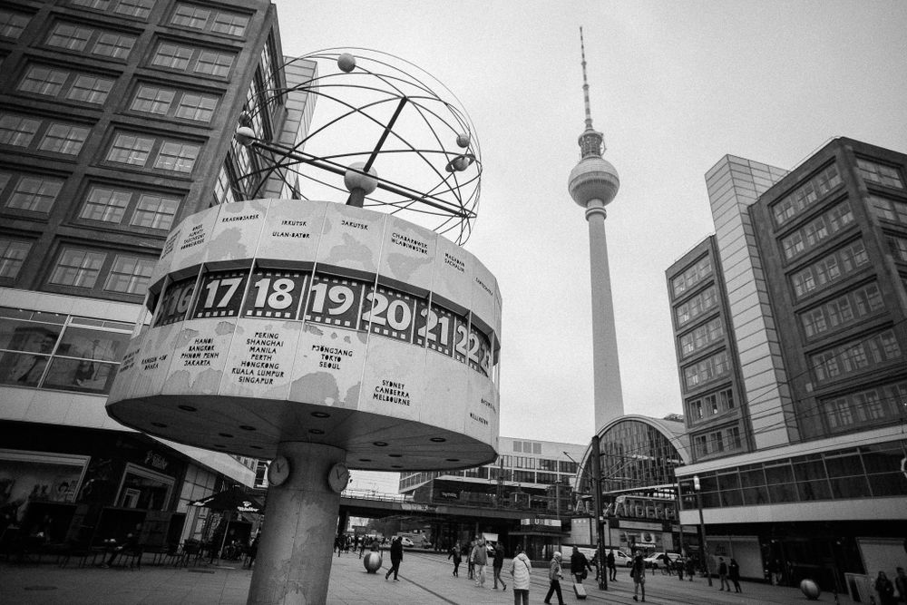 World Time Clock stands in Alexanderplatz with Berlin TV Tower in background.