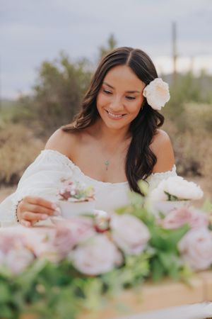 Romantic desert tea party scene with delicate pink roses and white porcelain teacups.