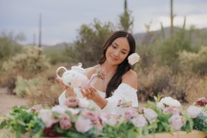 Dreamy desert photoshoot featuring vintage teacups and pink rose arrangements.