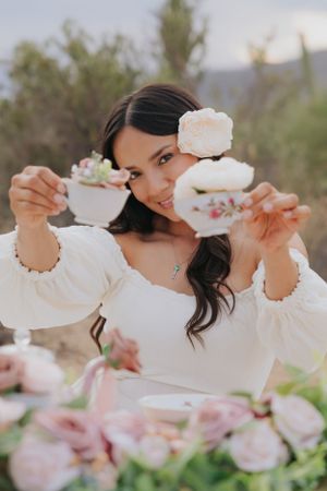 Whimsical tea party setup in Arizona desert with pink flowers and white teacups.