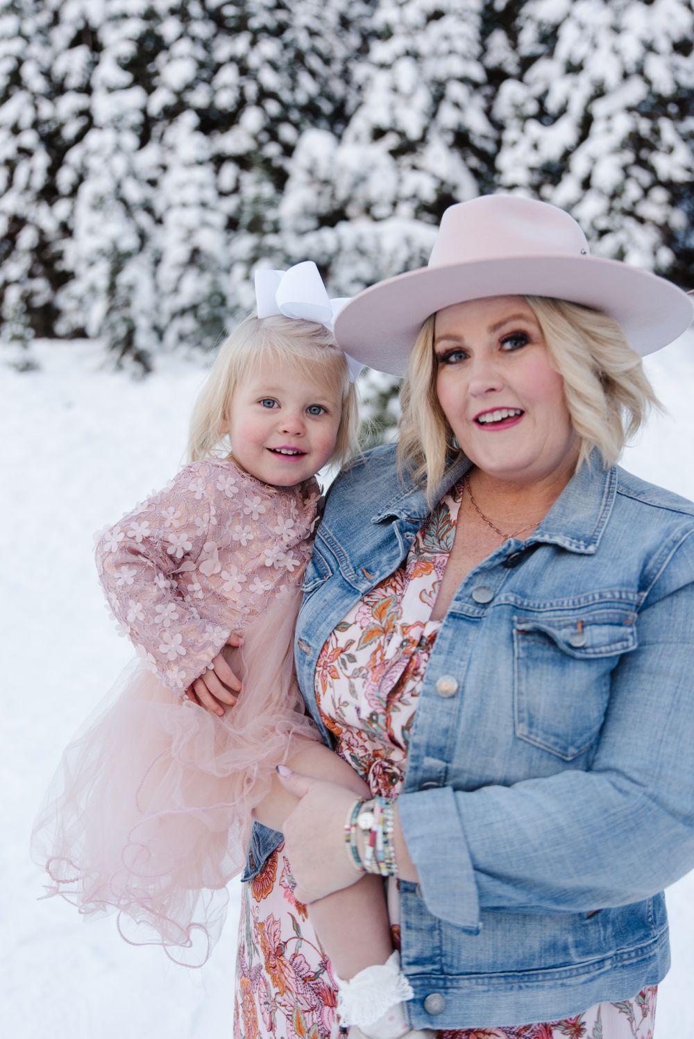 A winter portrait in the snow featuring pink dress and denim jacket fashion.
