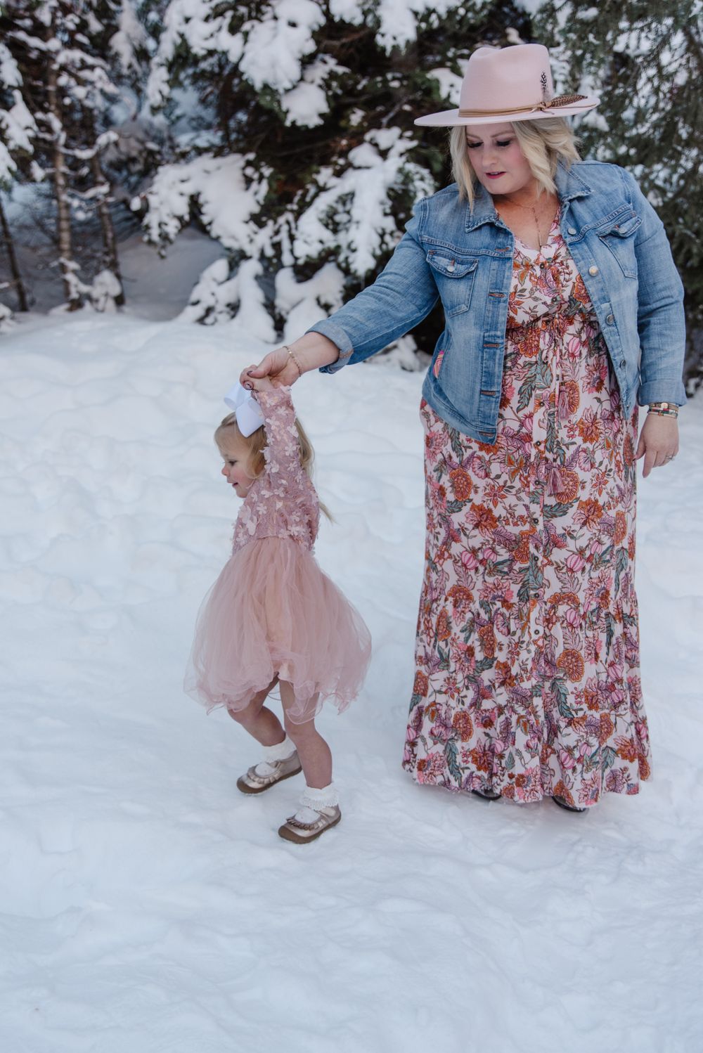 Dancing in the snow while wearing a floral dress and denim jacket.