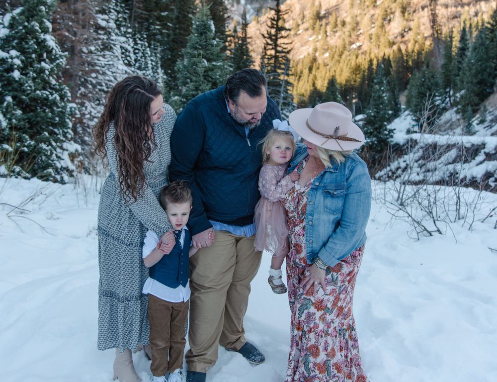 Family gathering in snowy mountain landscape during winter.