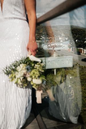 Detail shots of a white wedding dress with signage for Surfside in the background.