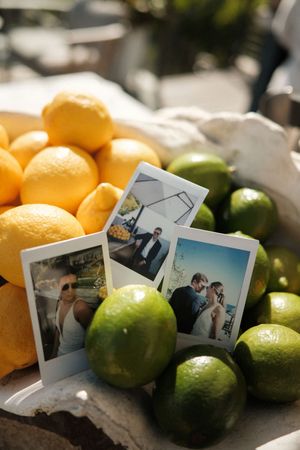 Fresh lemons and limes arranged with vintage polaroid photographs on a rustic surface.