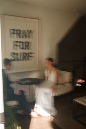 Motion-blurred artistic wedding photos taken in an indoor space with text on the walls.