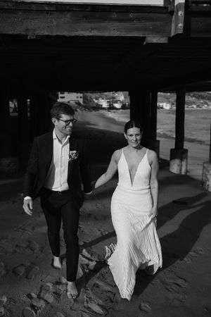 Black and white photograph of formal attire and shadows on a beach pathway.