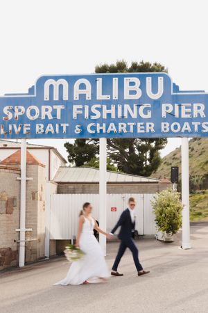 A sequence showing a couple walking under the vintage Malibu Sport Fishing Pier sign.