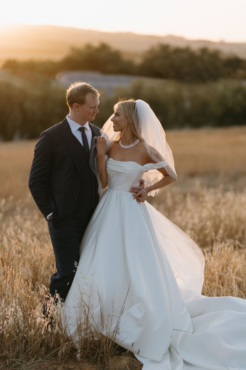 A romantic sunset wedding portrait in a golden wheat field.