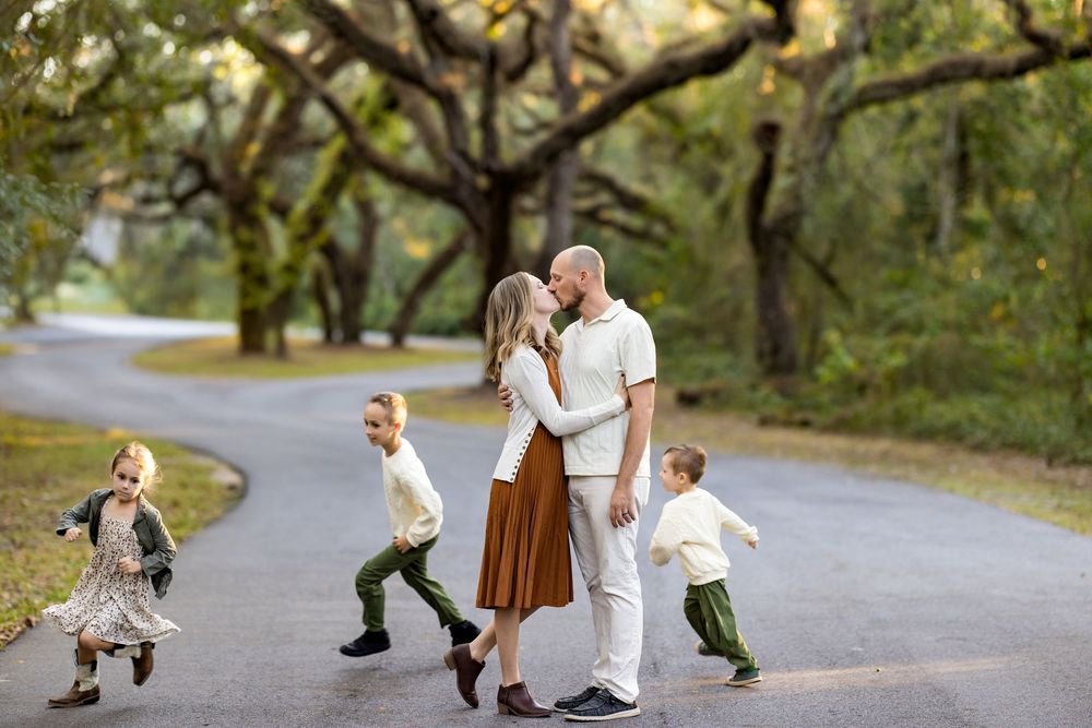 A family walks together on a winding path through a scenic park on a sunny autumn day.