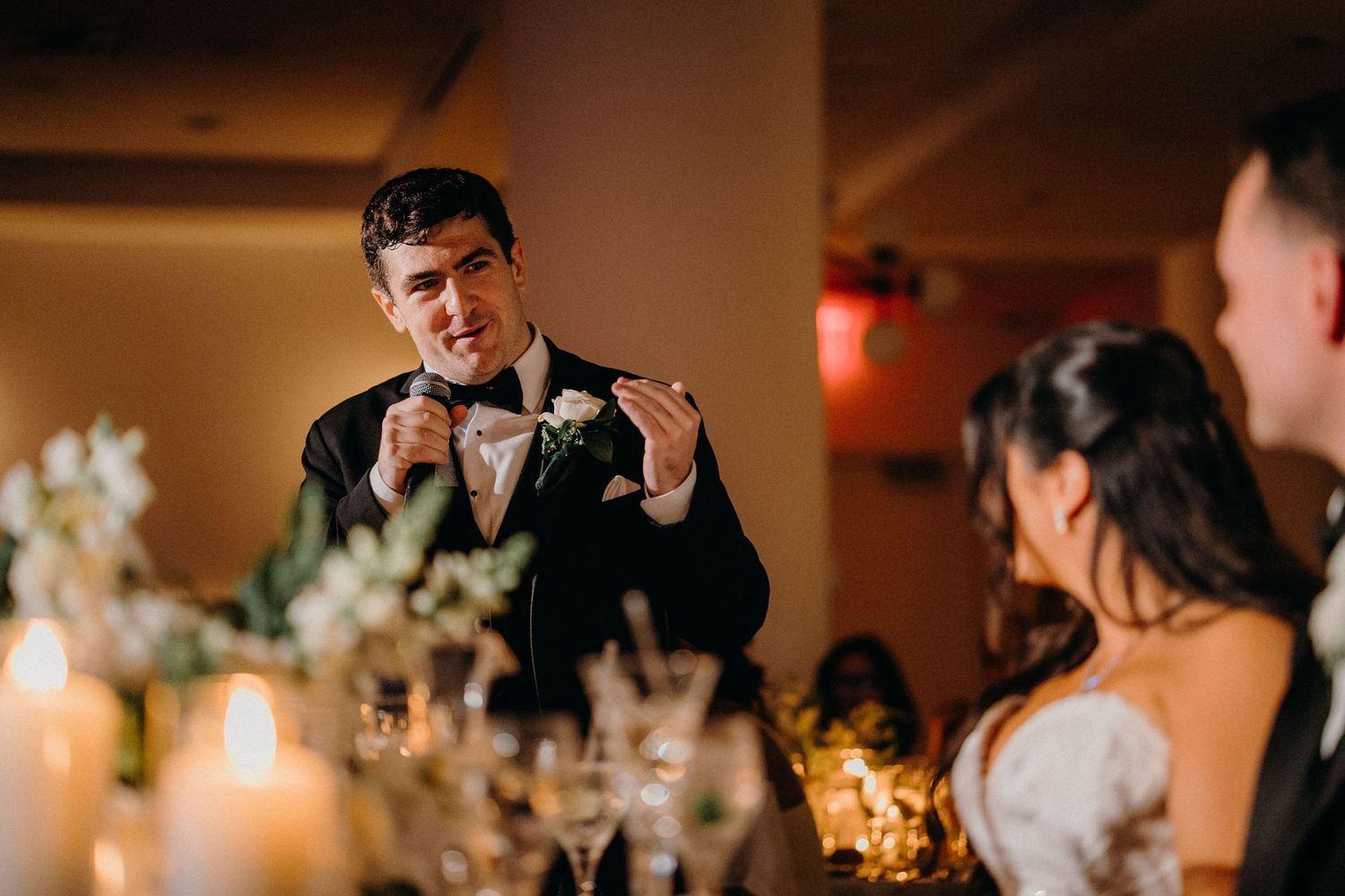 Wedding guests dance and celebrate on a warmly lit dance floor during an evening reception.