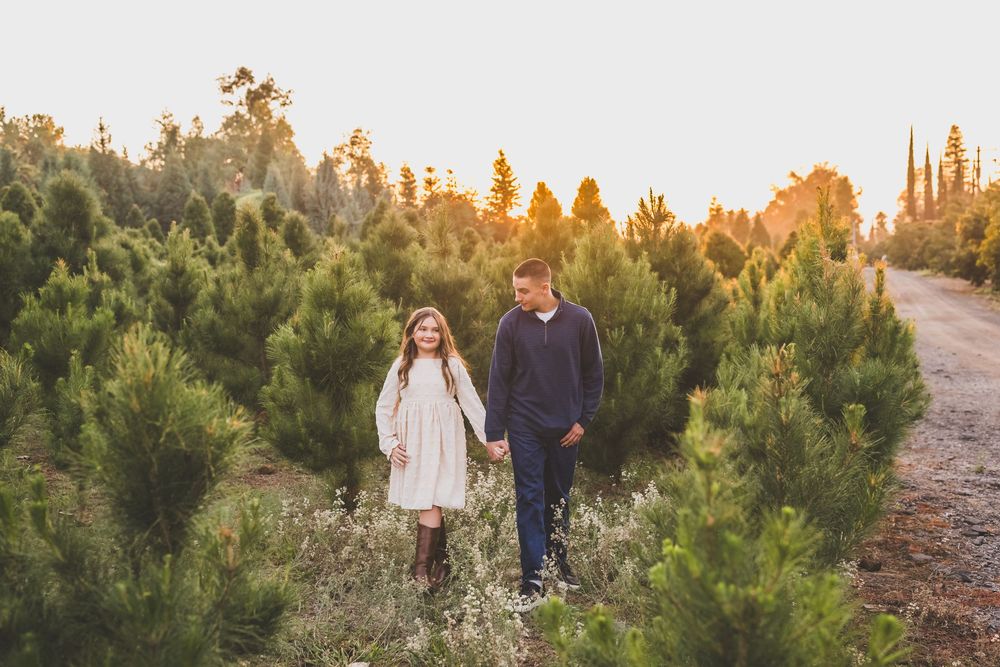 Family members walk together on a winding path through desert vegetation at golden hour.