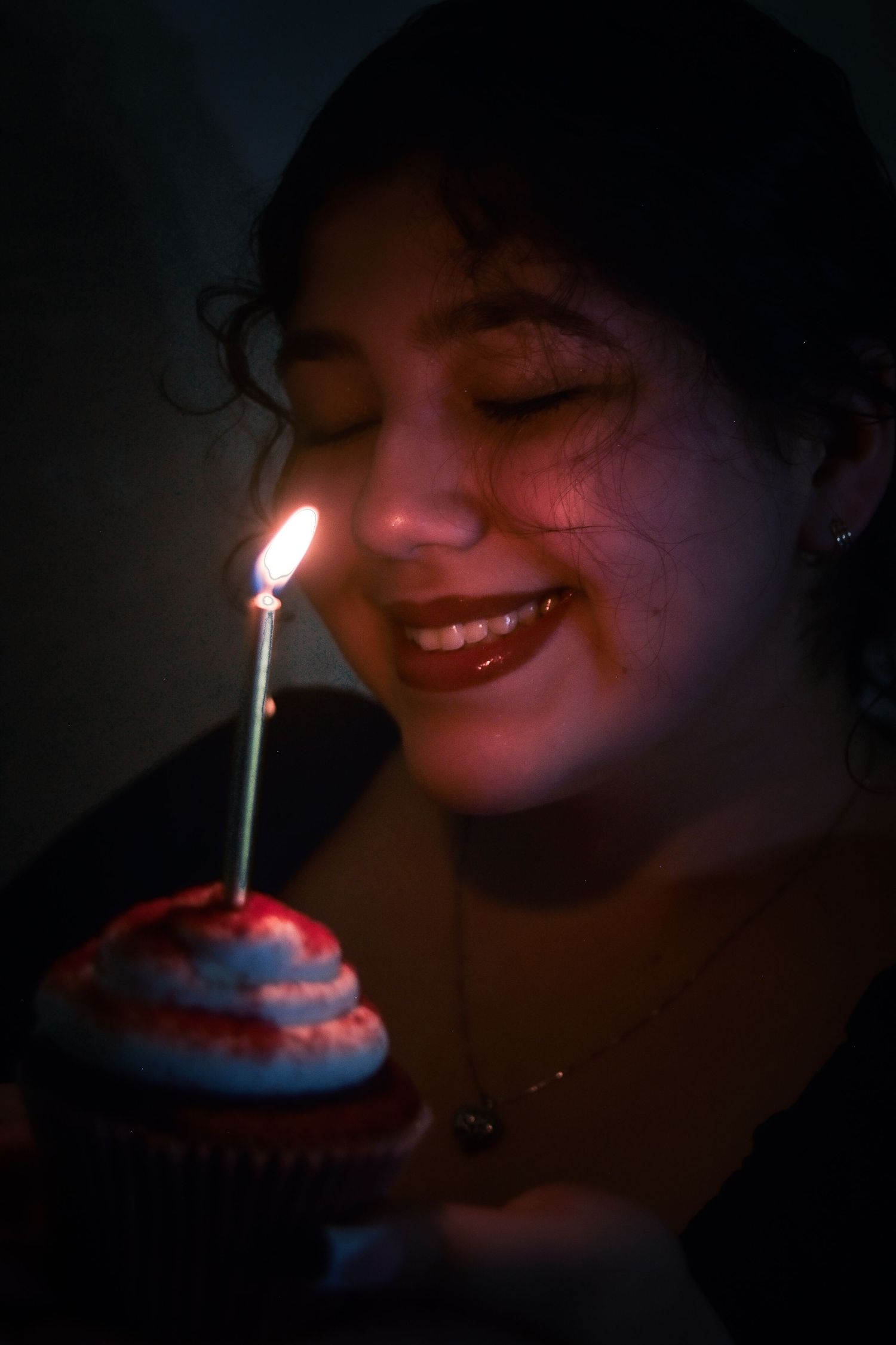 A sequence of photos showing someone blowing out a lit candle on a cupcake in a dark room.